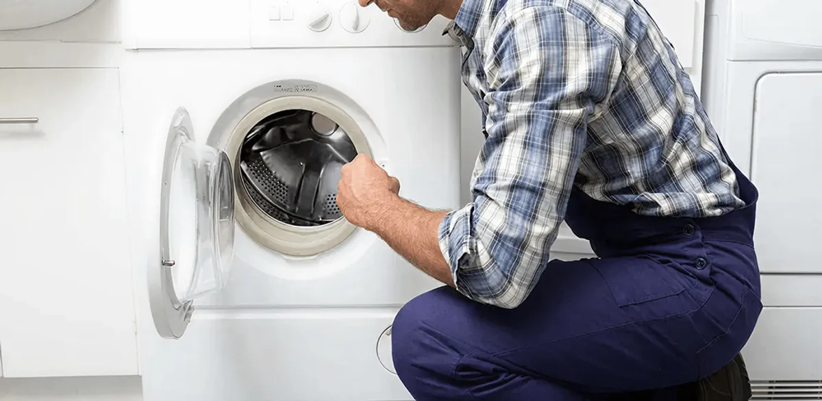 Handyman inspecting a dryer drum and internal parts for repair in Worcester, MA
