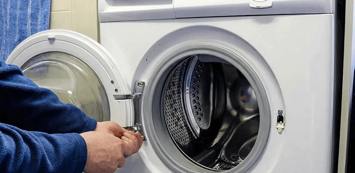 Washing machine repair handyman checking a front-load washer door and latch in Worcester, MA