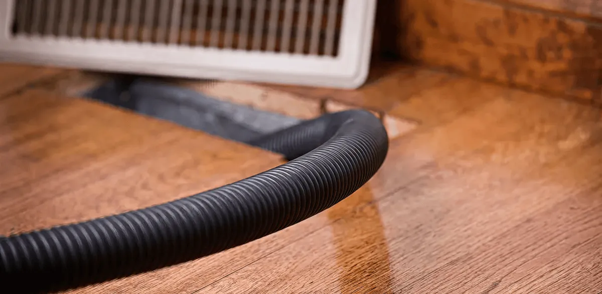Air duct cleaning hose inserted into a floor vent for ductwork cleaning in Worcester, MA