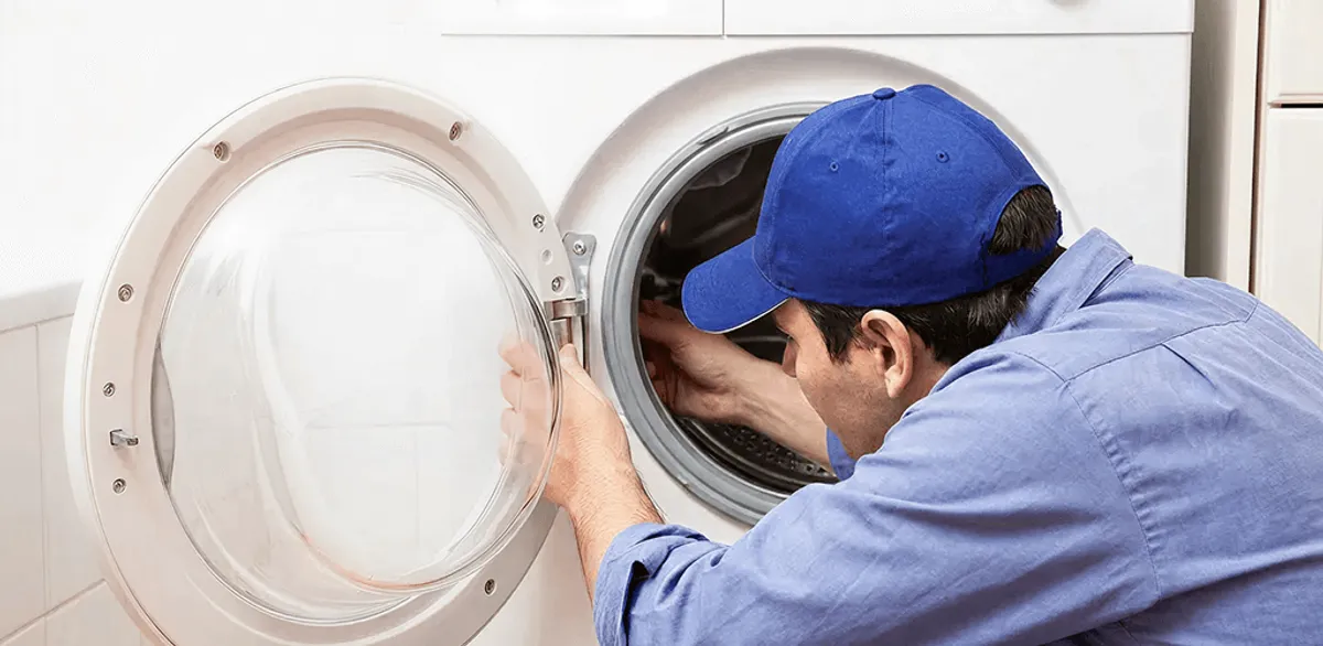 Washing machine repair handyman inspecting a front-load washer drum in Worcester, MA